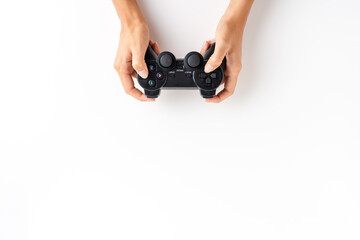 Woman’s hands playing video game controller over white background with copyspace. Top view