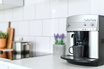 modern coffee maker with cup at kitchen with cozy interior