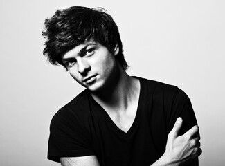 Portrait of a young handsome man in a black T-shirt. Fashion photography