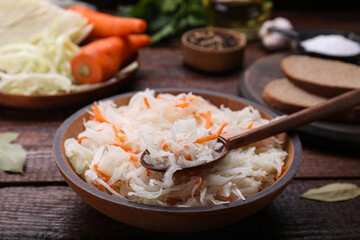 Bowl of tasty sauerkraut on wooden table, closeup