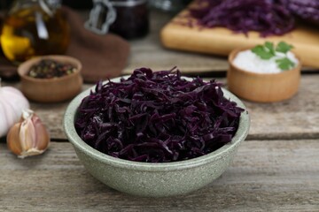 Obraz na płótnie Canvas Tasty red cabbage sauerkraut with parsley on wooden table