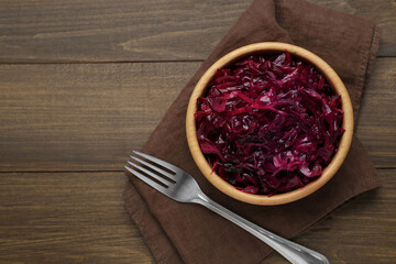Tasty red cabbage sauerkraut on wooden table, top view. Space for text