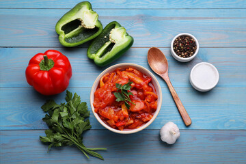 Delicious lecho and ingredients on light blue wooden table, flat lay