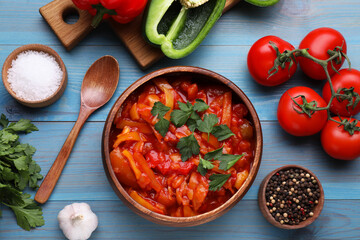 Delicious lecho and ingredients on light blue wooden table, flat lay