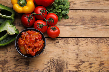 Delicious lecho and ingredients on wooden table, flat lay. Space for text