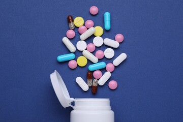 Bottle and antidepressant pills on dark blue background, flat lay