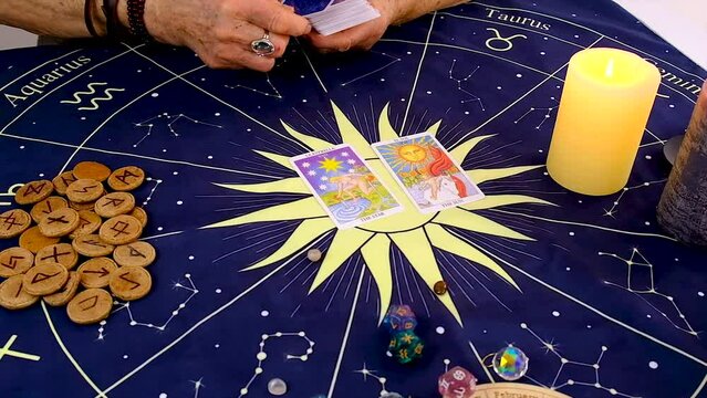 A fortune teller reads with tarot cards. Selective focus.
