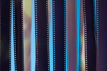 Veiled fragments of 35 mm film on blue background.