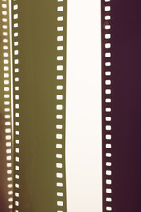 Obraz premium Veiled fragments of 35 mm film on white surface.