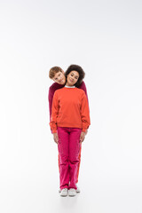 cheerful interracial couple in magenta color clothes showing i letter on white background.