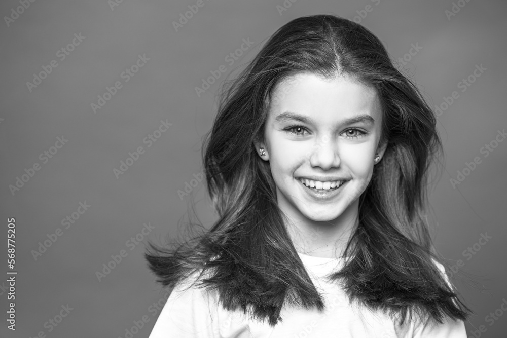 Wall mural Portrait of a charming little girl, isolated on gray background