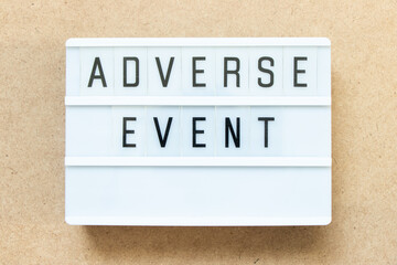 Lightbox with word adverse event on wood background