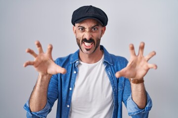 Hispanic man with beard standing over isolated background smiling funny doing claw gesture as cat, aggressive and sexy expression