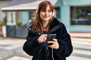 Young woman smiling confident listening to music at street