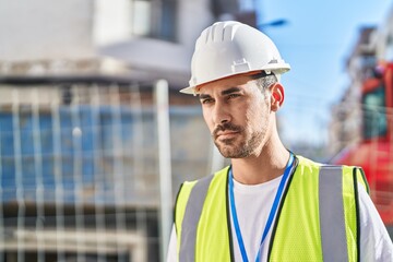 Young hispanic man architect standing with relaxed expression at street