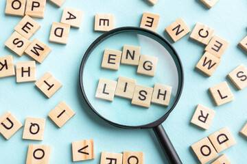 Square letter tiles with magnifying glass against blue background. Search for words and information...