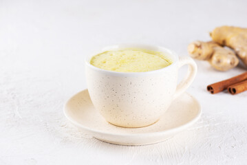 Indian turmeric latte from almond milk, ginger, turmeric and cinnamon in a mug, sugar and lactose free, healthy drink.