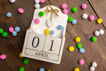 April 1st. Image of april 1 wooden calendar with colorful decor on wooden background. April Fool's...