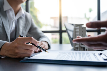 Entrepreneur, business owner, accountant, real estate agent A young Asian insurance agent explains the details of the condo purchase contract to calculate the financial risk for the client.