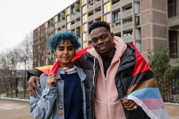 Fototapeta premium Portrait of young man and woman wrapped in progress pride flag