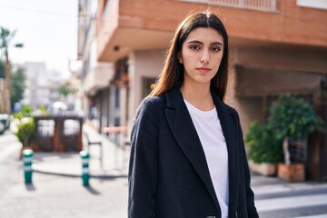 Fototapeta premium Young beautiful hispanic woman standing with serious expression at street