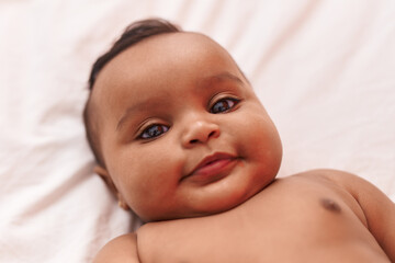 African american baby lying on bed at bedroom