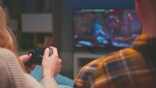 People Playing Video Game on Console Xbox Controllers Indoors Close-Up. Adult Couple of Friends Sitting and Gaming on Two Black and White Electronic Media Gadgets of PC. Wireless Cyber Tech for Hobby