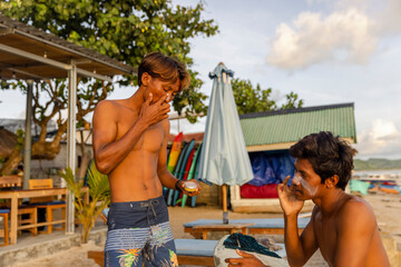 Fototapeta Surfer applying sun lotion on face at beach obraz