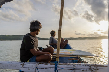 Fototapeta Indonesia, Lombok,�Surfers looking at sea view from boat at sunset obraz