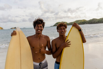 Fototapeta Indonesia, Lombok, Portrait of smiling surfers standing on beach obraz
