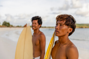 Fototapeta Indonesia, Lombok, Portrait of two surfers standing on beach obraz