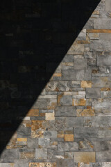 Shadow divides the stone wall in half. Different size cut out gray marble wall texture.