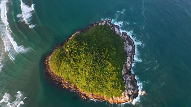 Die Insel Ilha do Batuta vor dem Strand Praia do Luz und Praia da Rosa. Insel aus der Luft gefilmt. Kleine Insel sieht wie ein Herz aus. Blaues Meer und Wellen 3