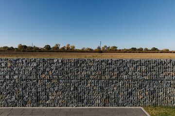 The crushed stone is fixed in the mesh. A fence made of natural stone, crushed stone, granite.