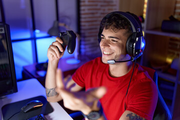 Young hispanic man streamer playing video game using joystick at gaming room © Krakenimages.com