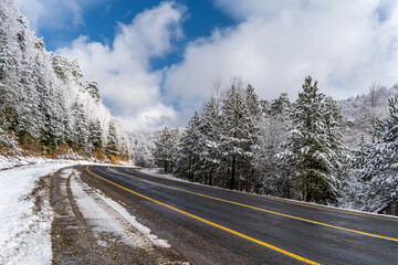 Mountain road landscape covered in snow in winter - 568793228