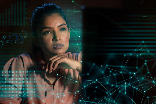 Businesswoman working on laptop computer with icons on virtual screen