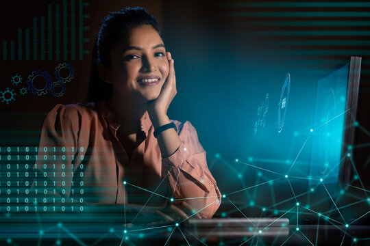 Businesswoman working on laptop computer with icons on virtual screen