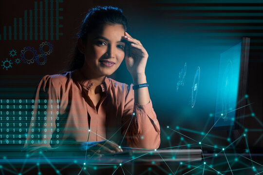 Businesswoman working on laptop computer with icons on virtual screen