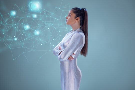 A woman wearing silver futuristic clothes looking into a virtual Screen