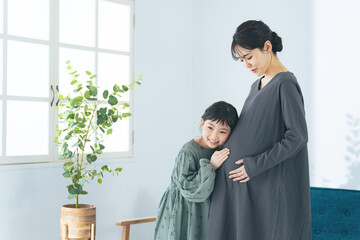 妊婦ママのお腹に耳を当てる女の子