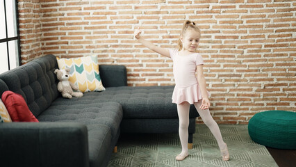 Adorable blonde girl ballerina smiling confident dancing at home