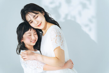 寄り添う女性と女の子　親子の美容イメージ