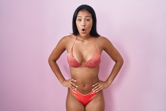 Hispanic woman wearing bikini afraid and shocked with surprise and amazed expression, fear and excited face.