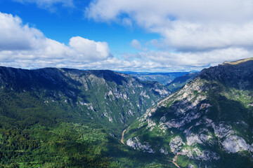 Naklejka premium View of the mountain river. Mountain peaks in summer.