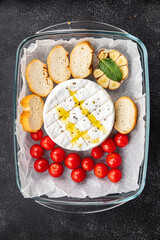 baked cheese Brie or Camembert with tomato, garlic and herbs healthy meal food snack on the table copy space food background rustic top view