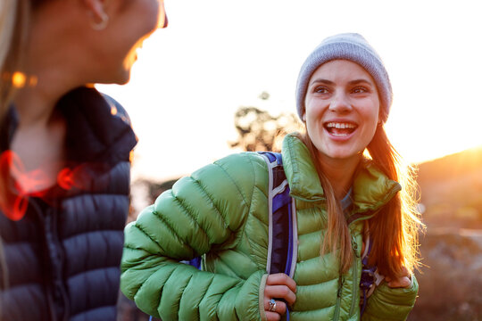 Female friends talking and hiking during sunrise