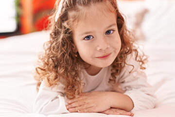 Fototapeta premium Adorable blonde toddler smiling confident lying on bed at bedroom