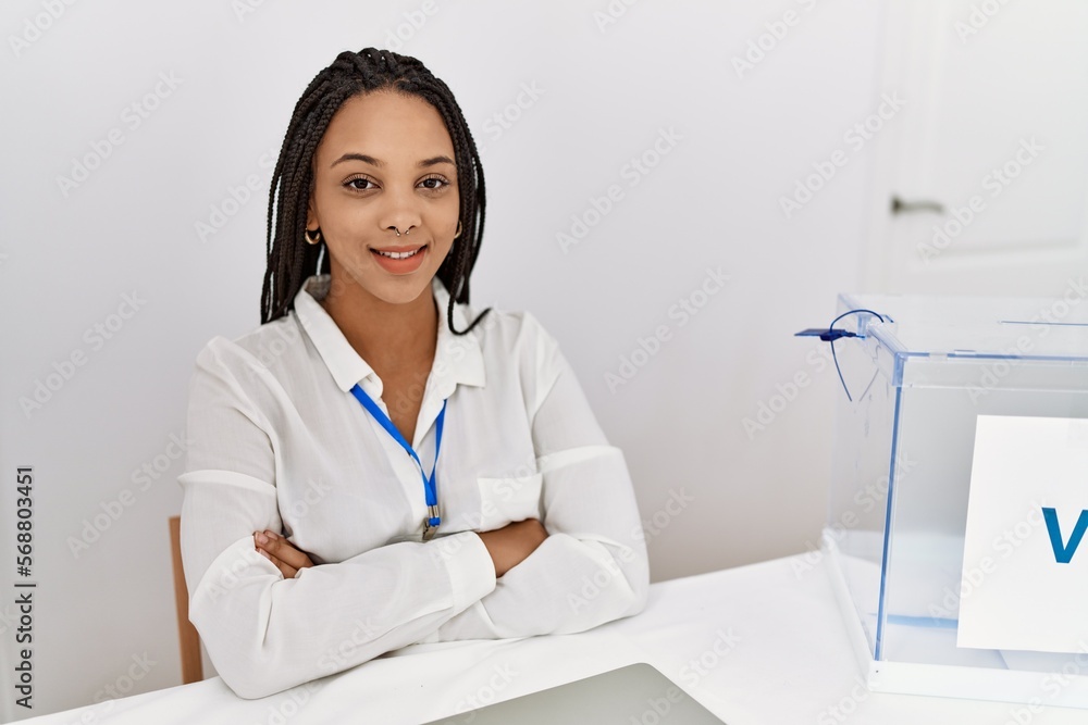 Sticker Young african american woman smiling confident with arms crossed gesture at electoral college