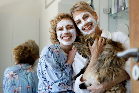 Mother and daughter spending quality time together wearing facial mask and cucumber.